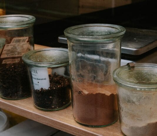 Jogurtowa kuchnia zero waste: jak wykorzystać serwatkę, resztki mleka i nadmiar jogurtu Szklane słoiki z przyprawami ustawione rzędem na kuchennej półce