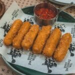 Chrupiące paluszki serowe z sosem pomidorowym na restauracyjnym talerzu
