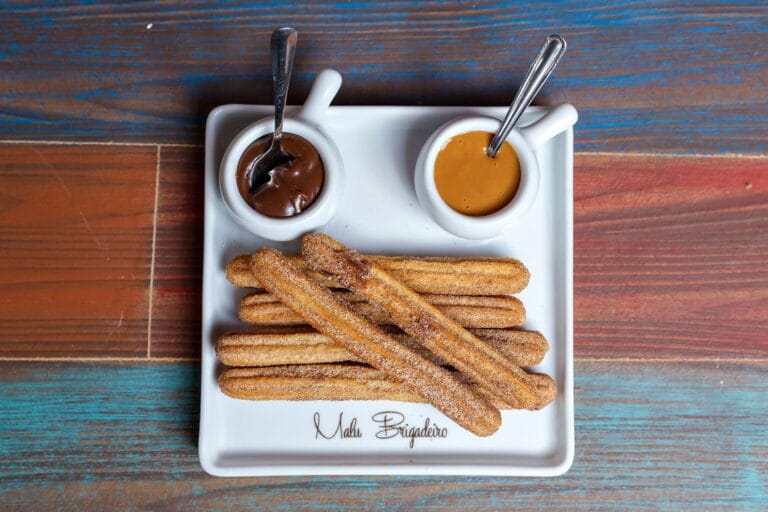 Churros z dipem czekoladowym i kajmakowym na drewnianym stole